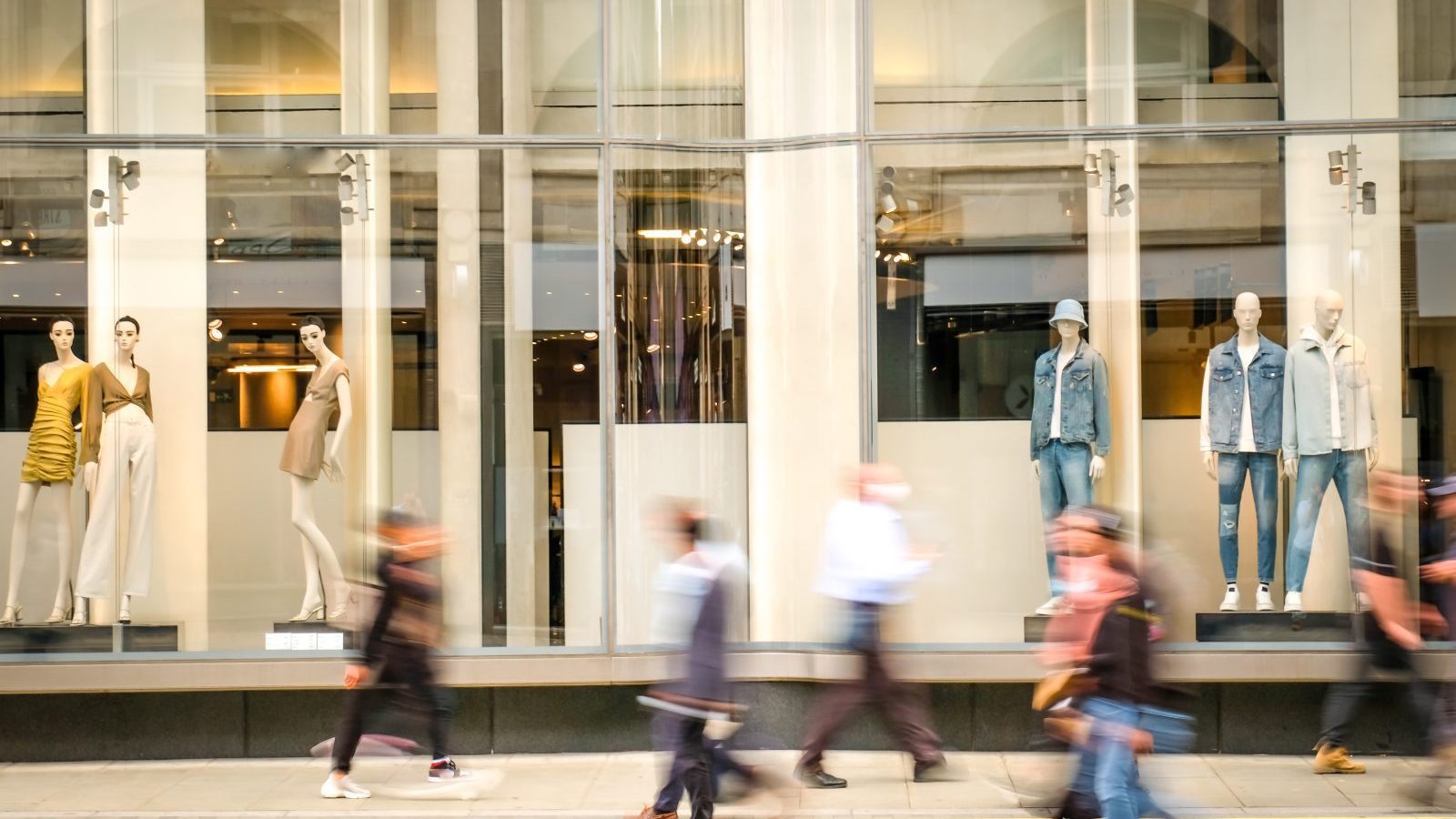 Motion blurred people walking past retail shop window on London Foto: William/AdobeStock