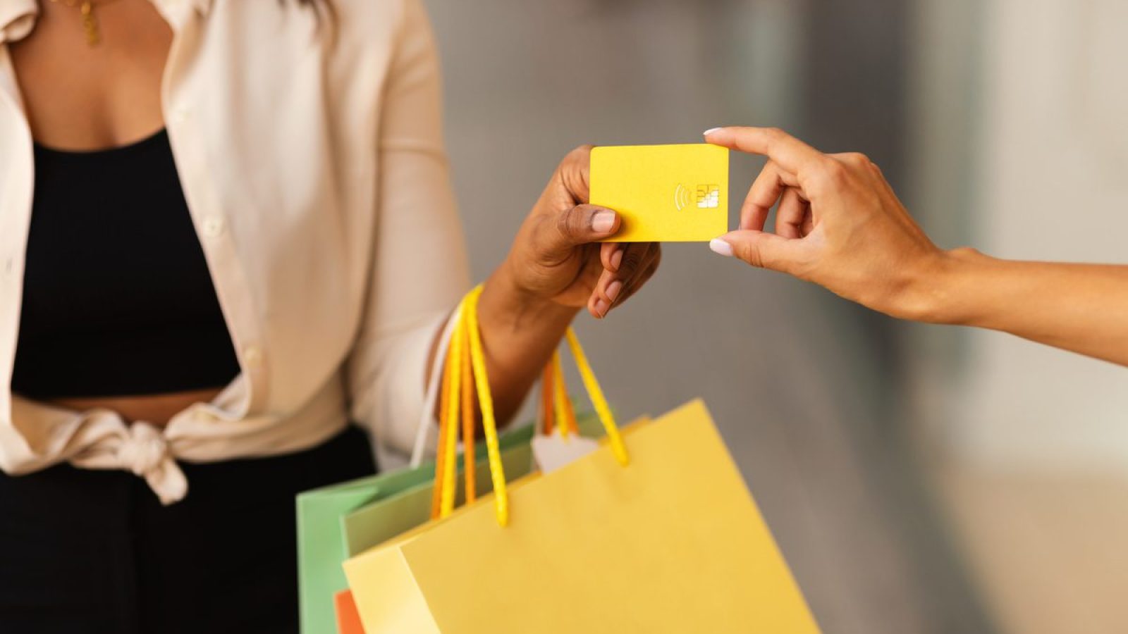 Unrecognizable black woman giving credit card to female vendor compras-black-friday